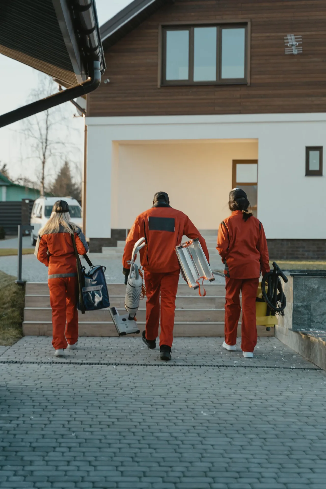 Cleaning team carrying equipment to a house