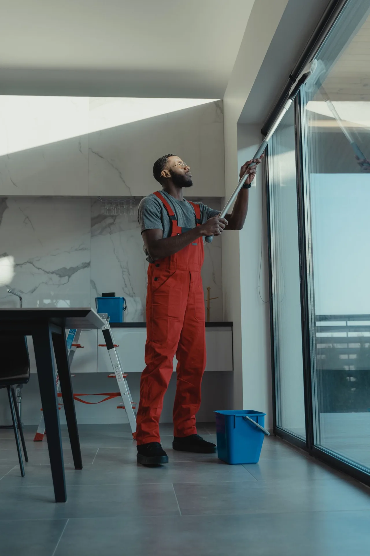 Cleaner washing large windows in a modern space